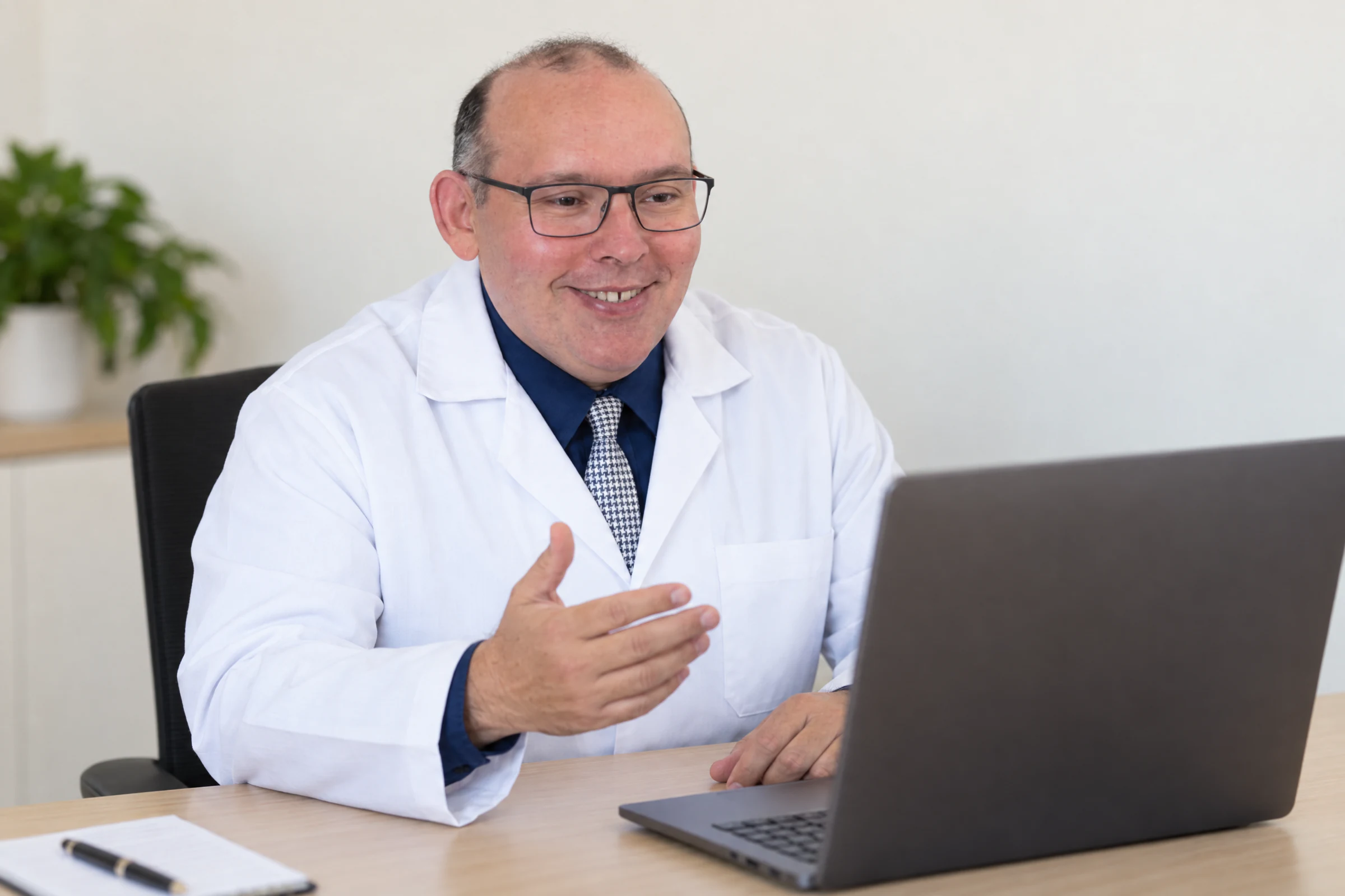 Dr. Avelino Júnior em consulta por videochamada diante do notebook